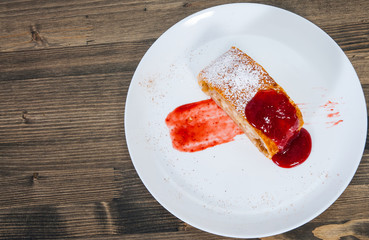 Strudel with apples and berry sauce on plate