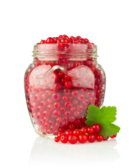 Fresh red currant with green leaf in glass jar