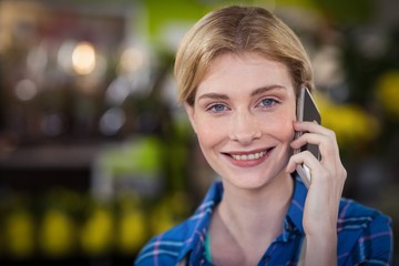 Female florist talking on mobile phone