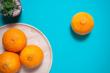 Fresh orange fruits and juice on blue table.