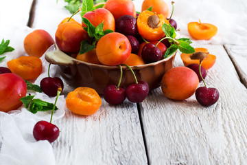 Ceramic bowl with organic ripe apricots and cherries