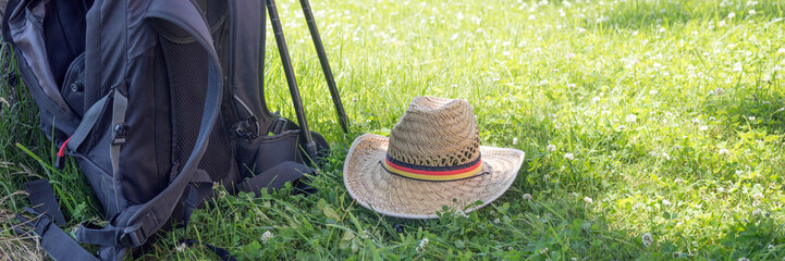 Rucksack, Wanderstöcke und Hut auf der Wiese