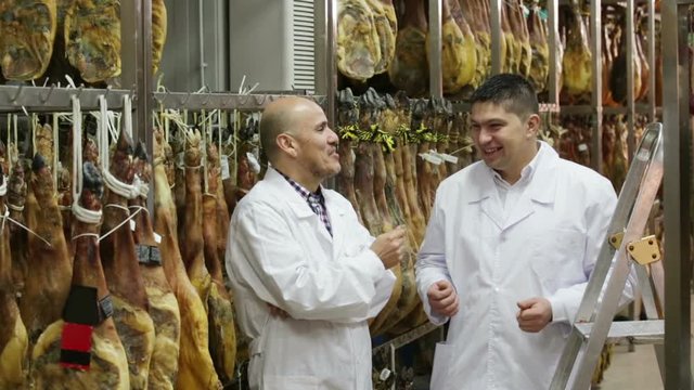 workers checking condition of serrano jamon 