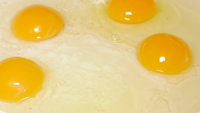 Eggs frying on hot oil 4K 2160p UHD video - Fresh organic eggs in ceramic frying pan 4K 3840X2160 UHD footage 