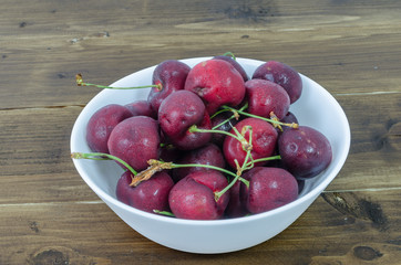 Cood cherry serve in white bowl on wood table