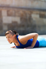 Fototapeta na wymiar Woman doing pushups outdoor.