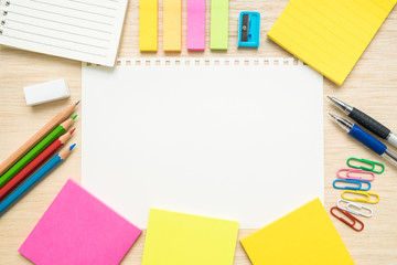 Table top view of stationery items  with empty line paper on woo