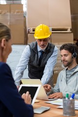 Workers using digital devices in warehouse
