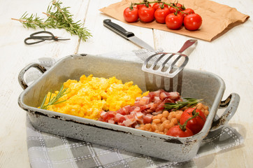 british breakfast with scrambled eggs in a roasting tin