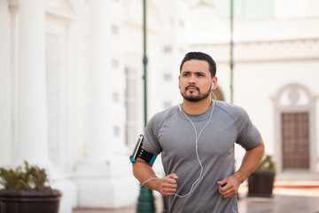Man running in the city and listening to music