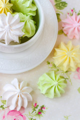 Fototapeta na wymiar Colorful meringues in white tea cup