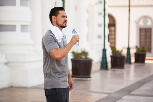 Young man drinking water and exercising