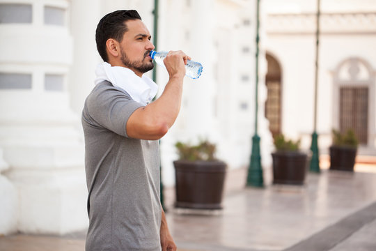 Young man drinking water outdoors