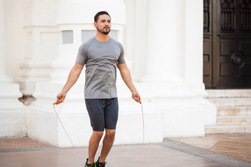 Young man jumping a rope outdoors - obrazy, fototapety, plakaty