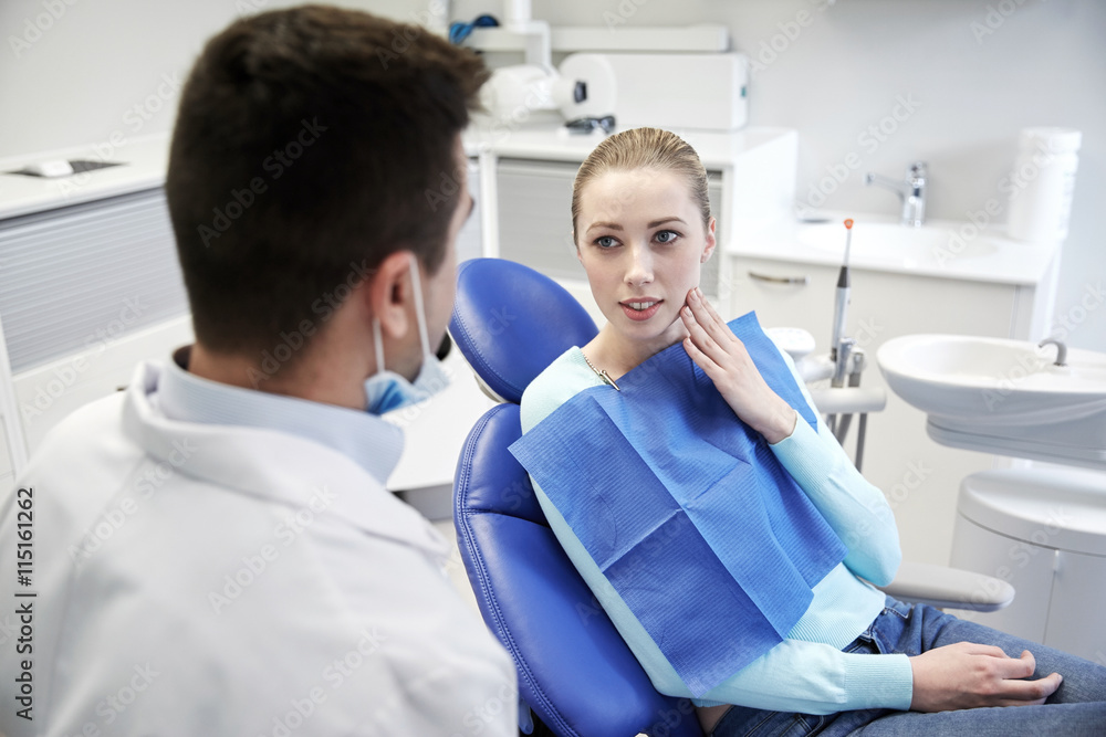 Wall mural male dentist with woman patient at clinic