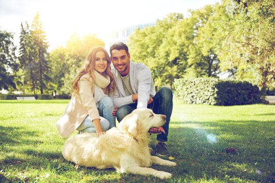 happy couple with labrador dog walking in city