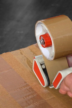 Taping box tape dispenser / Man taping a cardboard box with a tape dispenser