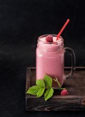 Smoothies or Milkshake with raspberries and cream in a glass jar