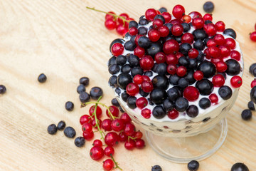 Dessert with cream and fresh berries (red and black currants, blueberry)