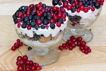 Dessert with cream and fresh berries (red and black currants, blueberry)