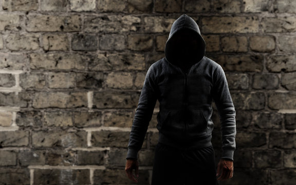 Mann mit einem Hoodie vor einer Mauer