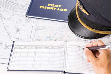 Close up of an airplane pilot hand filling in an flight log with