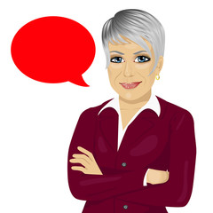 attractive senior businesswoman with arms folded standing near red blank speech bubble