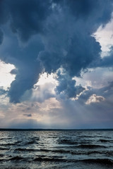 Storm clouds and sunbeams under lake