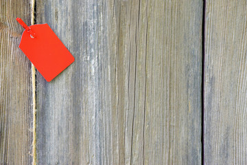 Blank red tag on wooden background.