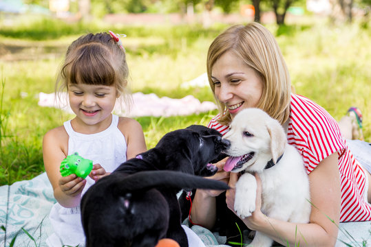 Mom and daughter with labrador puppy