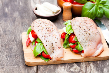 Raw  chicken breasts stuffed with mozzarella and vegetables