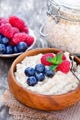 Porridge  in a wooden bowl with berries