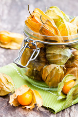 Ripe  physalis in a glass jar on wooden table