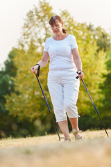 Ältere Frau macht Nordic Walking