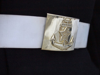 Shiny brass buckle on white sailor belt