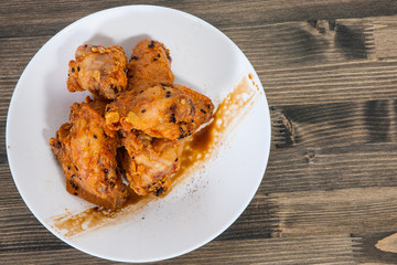 Sticky Chinese Chicken Wings with soy sauce and sesame on wooden table