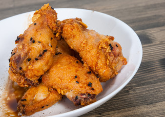 Sticky Chinese Chicken Wings with soy sauce and sesame on wooden table