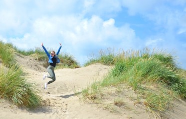junge Frau macht einen Luftsprung, Insel Rømø, Dänemark