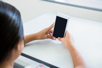 Cropped image of girl using mobile phone