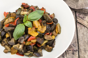 Ratatouille with eggplant, zucchini, red and yellow peppers on wooden background3