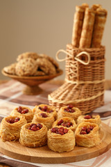 Kunafa with roasted peanuts on a wooden board and different  baking.