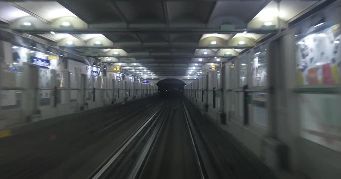 Driveless subway train arriving to the station from dark tunnel, view from the cabin