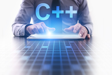 Businessman is pressing button on tablet pc and selecting C++.  