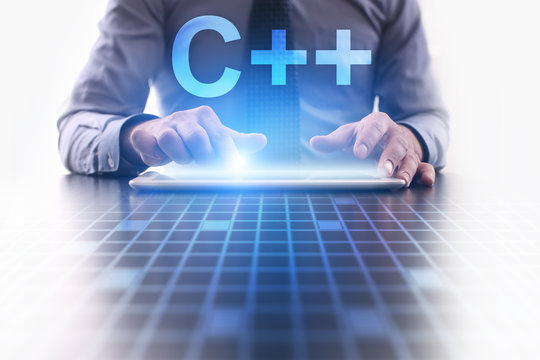 Businessman is pressing button on tablet pc and selecting C++.  