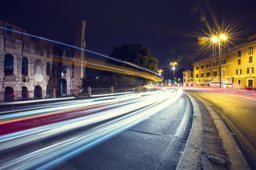 Fototapeta na wymiar car trails and night lights around colosseum in Rome in Italy