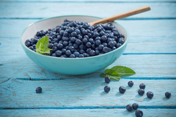 blueberries in plate on a blue wooden table