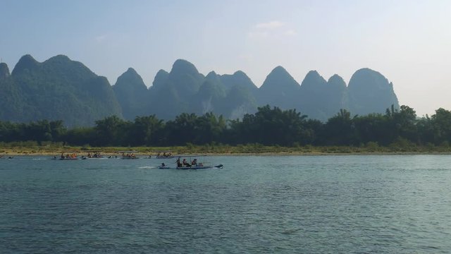 Tourist rafts are sailing over the Li river at a beautiful sunset, around the Yangshuo/Guilin area in China