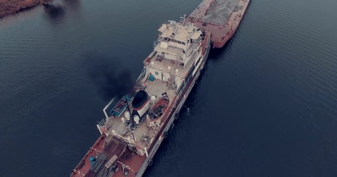 Aerial view of  barge transporting gravel down Moskva River on a cloudy autumn day in Strogino district, Moscow, Russia.  