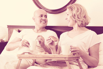 Obraz na płótnie Canvas Couple having breakfast in bed