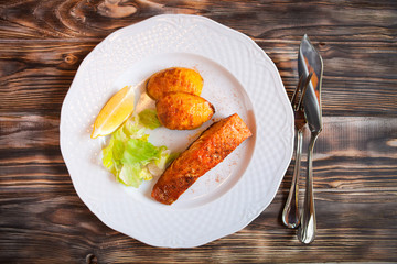 Grilled Salmon with potatoes, slice of lemon on wooden backgroun